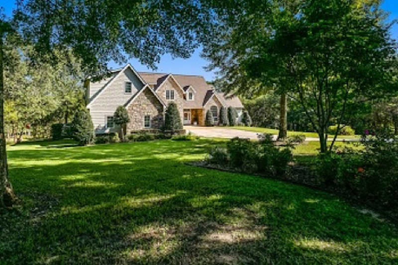 house made of stones green lawn with trees