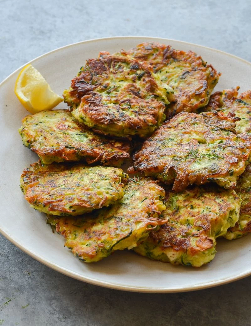 white plate with stacked zucchini patties