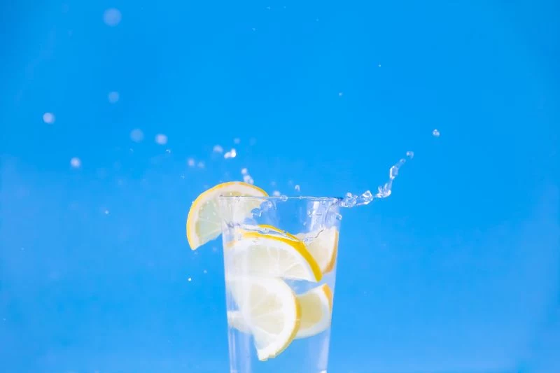 benefits of lemon water lemon slice splashing in water