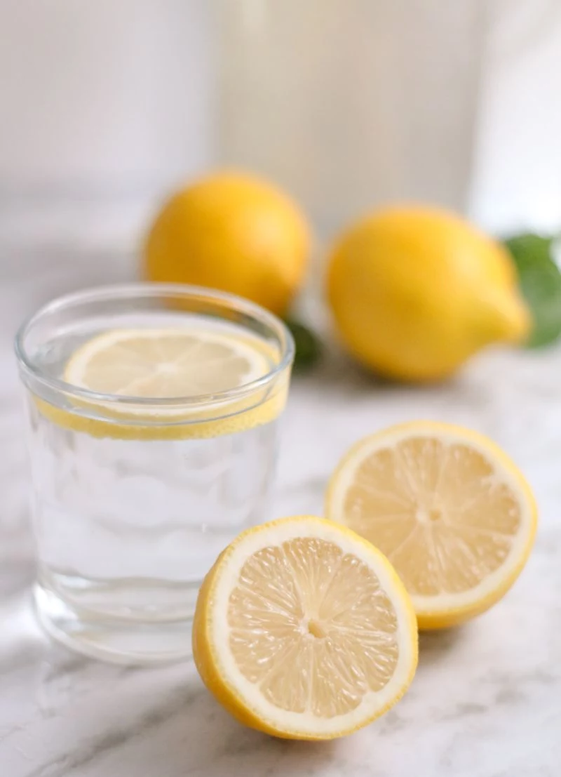 halved lemon benefits of lemon water glass of water