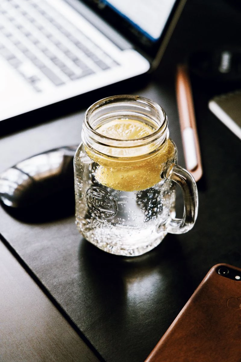 lemon water in the morning glass next to laptop