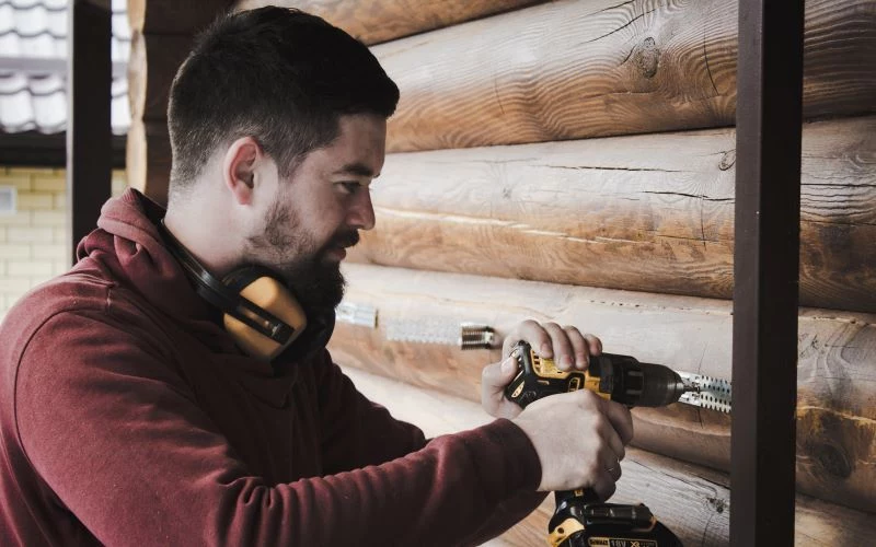 man drilling home improvements wearing headphones