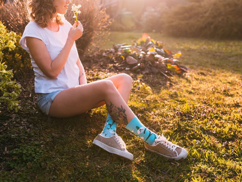 woman sitting on wooden log high socks with prints