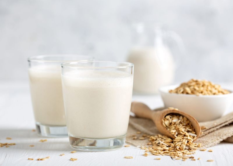 glasses jug filled with homemade oat milk