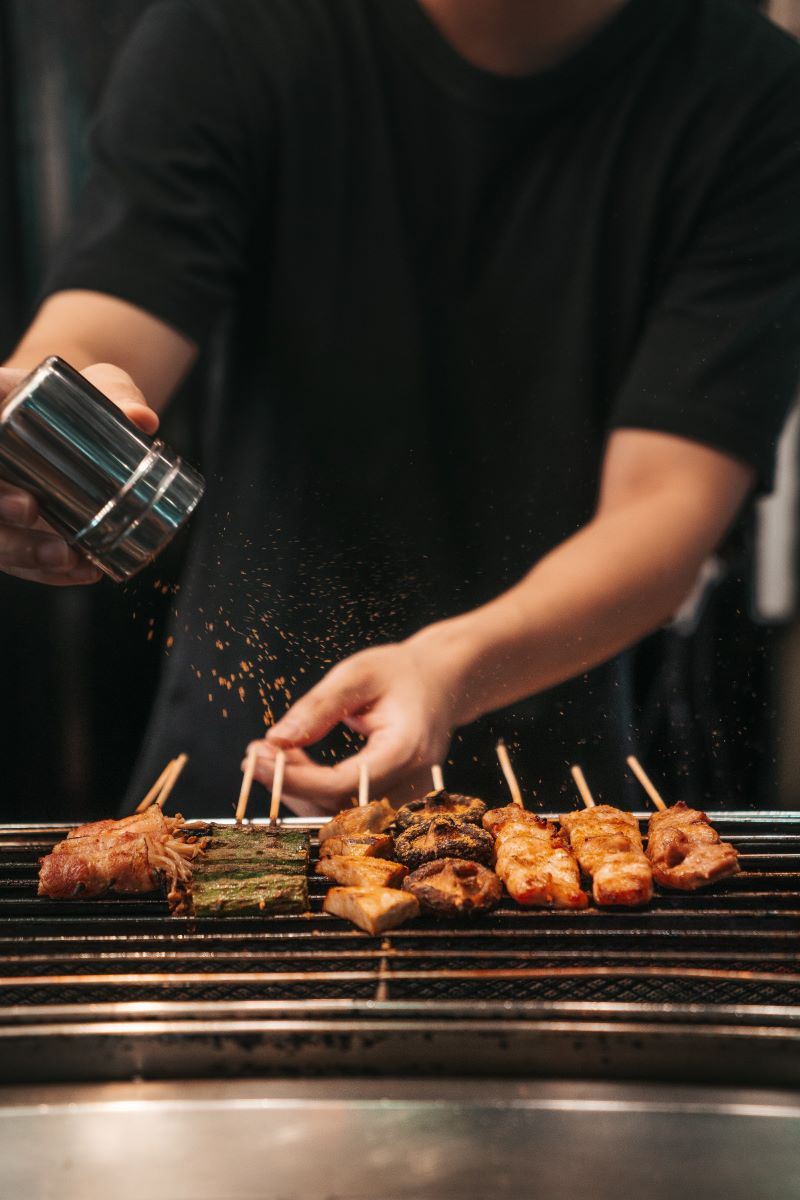 man seasoning skewers bbq tips meat