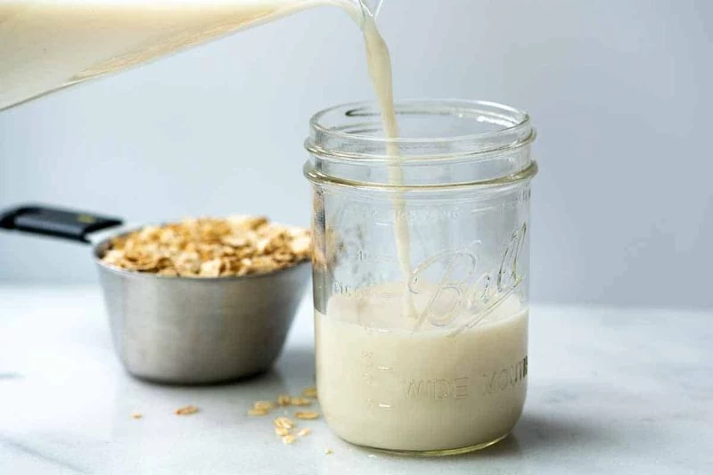 oats in measuring spoon oat milk recipe jar