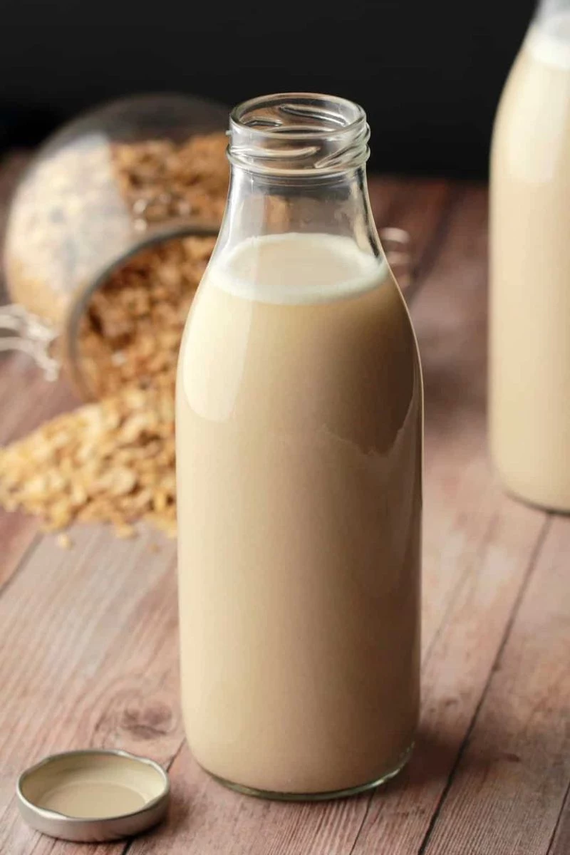 tall bottle make oat milk wooden surface