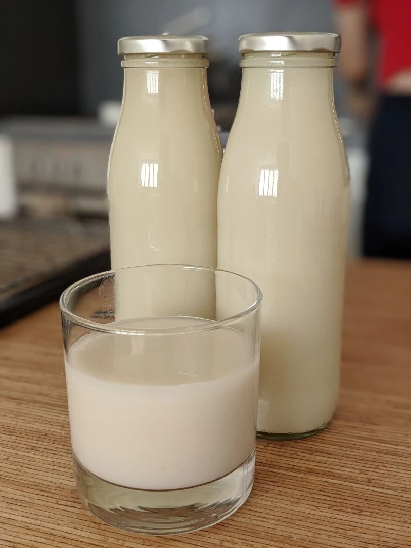 two bottles glass homemade oat milk