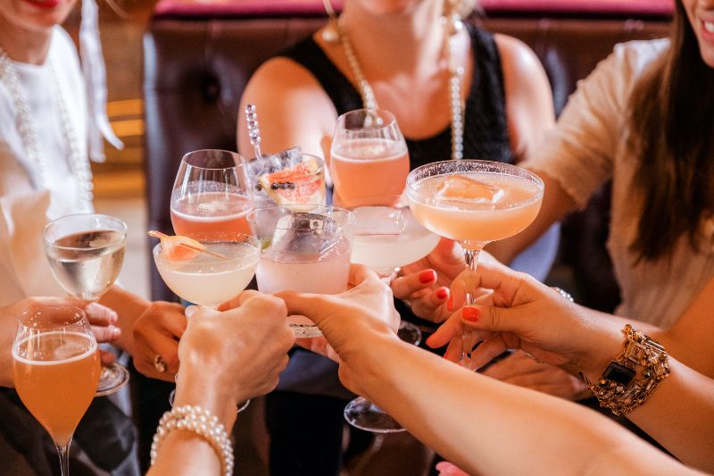 women making toast gin mixed drinks