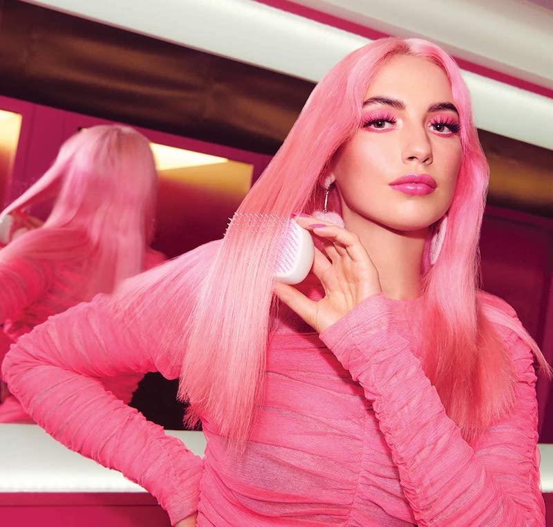 beautiful woman with pink hair using pink tangle teezer brush