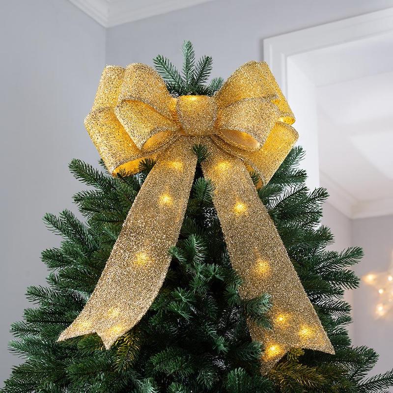 christmas tree topper ideas sparkly and glittery golden ribbon bow on top of tree