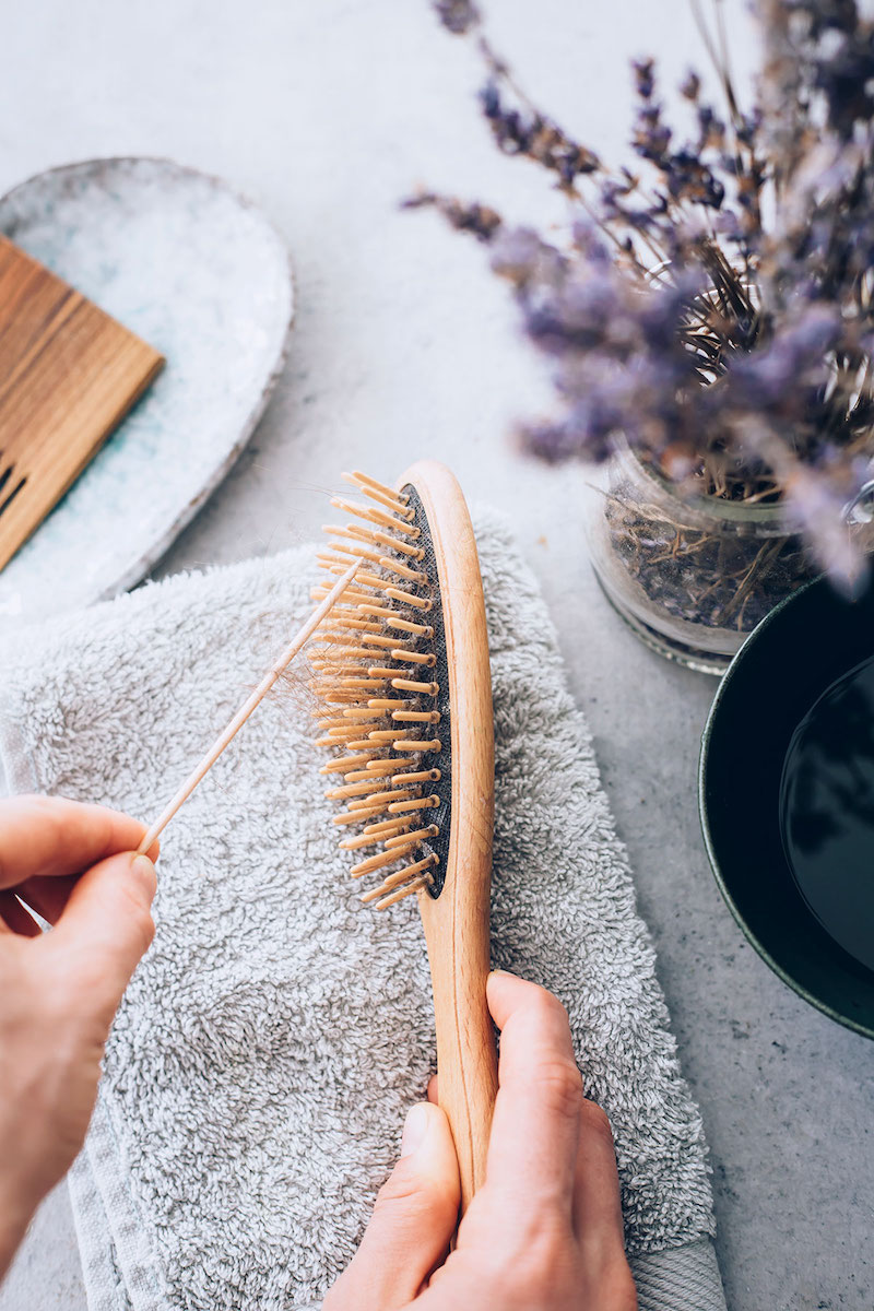 cleaning lint on hairbrush at home with a toothpick