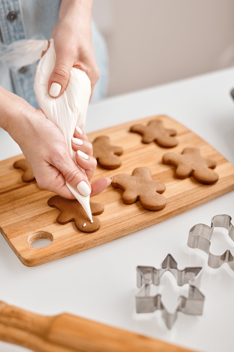 decorating gingerbread cookies with white frosting and a transparent bag