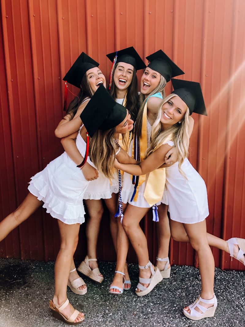 five girls wearing white graduation dresses 2021