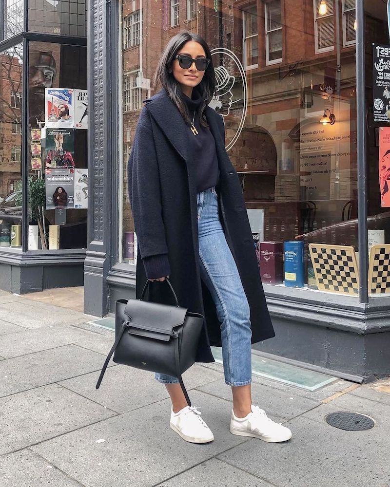 girl wearing black long coat white shoes and jeans