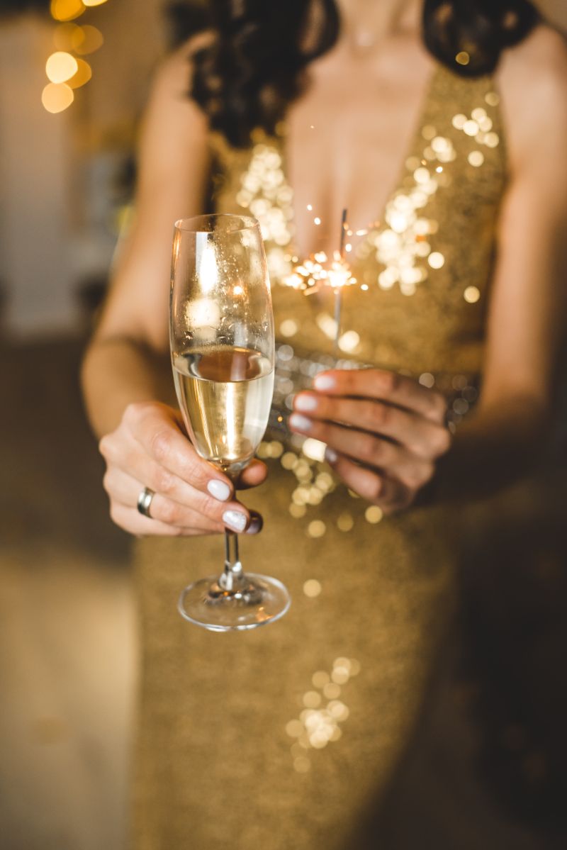 gold dress christmas champagne cocktail in hand
