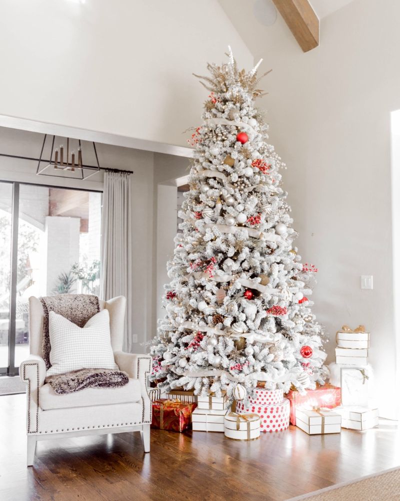 large frosted christmas tree with red baubles