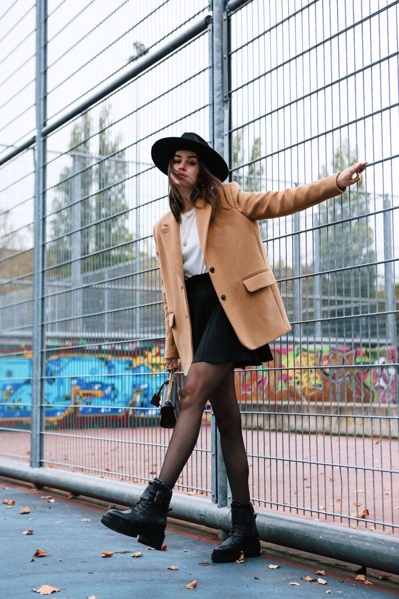 short black skirt black platform boots beige jacket