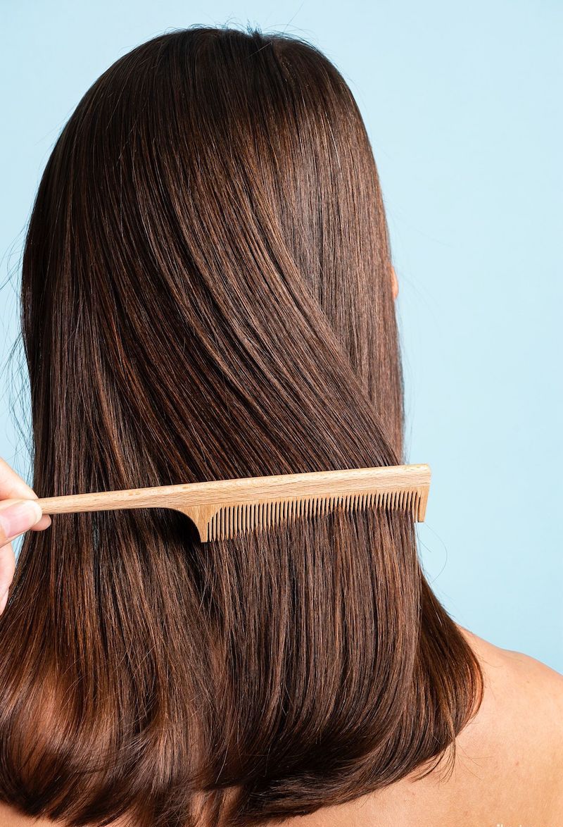 using wooden hair comb to keep hair fizz free and soft
