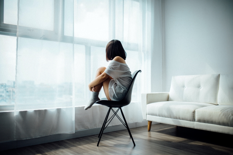 woman sitting in front of window mental health