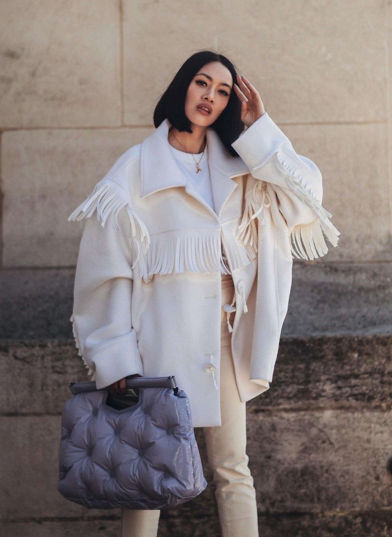 woman wearing oversized white jacket in 60 degree weather