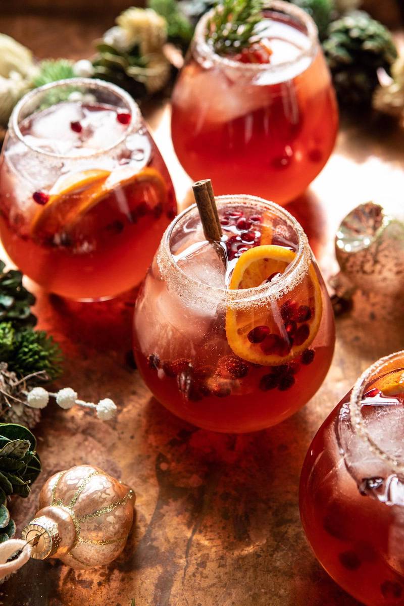 sparkling cranberry christmas cocktail with orange slieces and cinnamon sticks