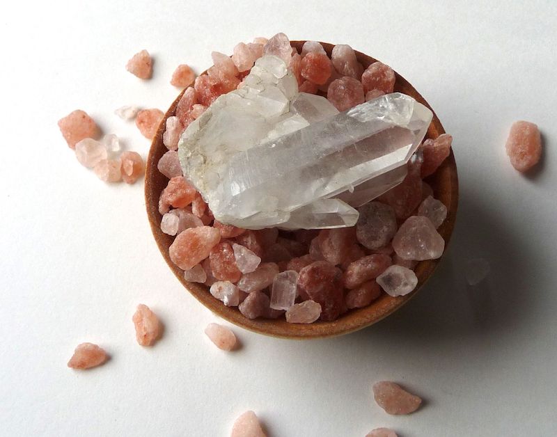 cleaning clear quartz crystal using a bowl full of pink himalayan salt