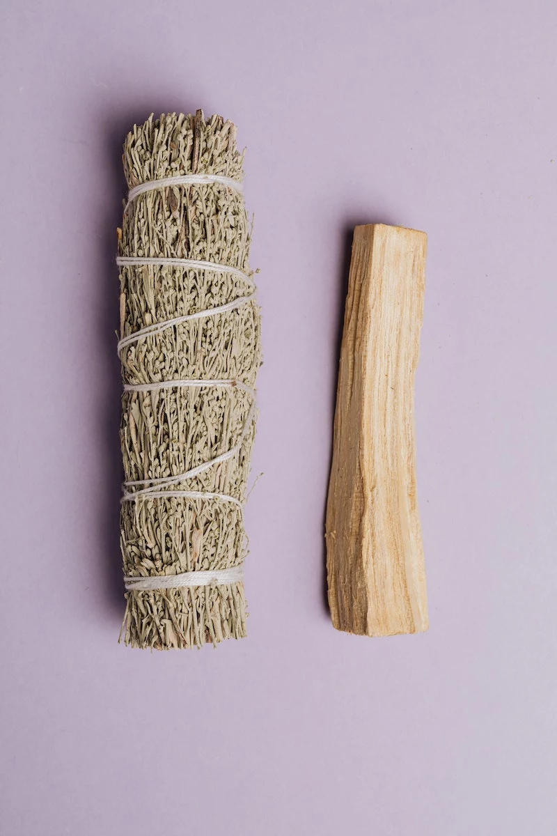 cleansing crystals using white sage and palo santo tree smoke