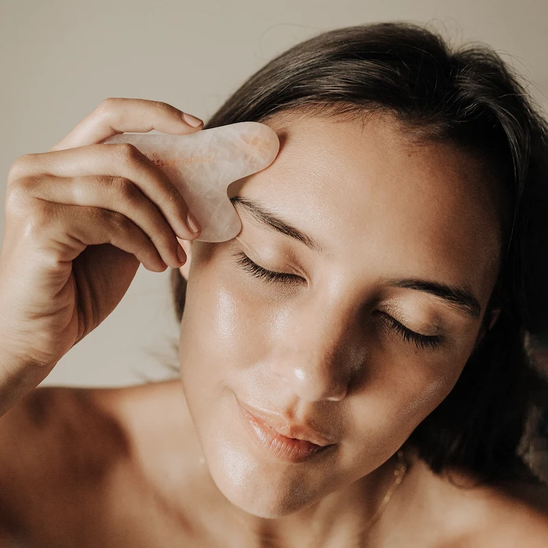 girl using authentic rose quartz gua sha to massage and contour face