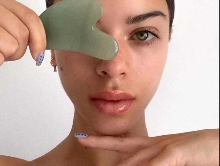 muscle scraping with authentic facial gua sha tool made from green aventurine