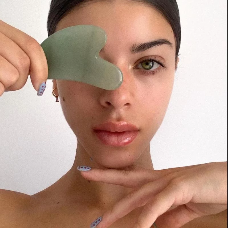 muscle scraping with authentic facial gua sha tool made from green aventurine