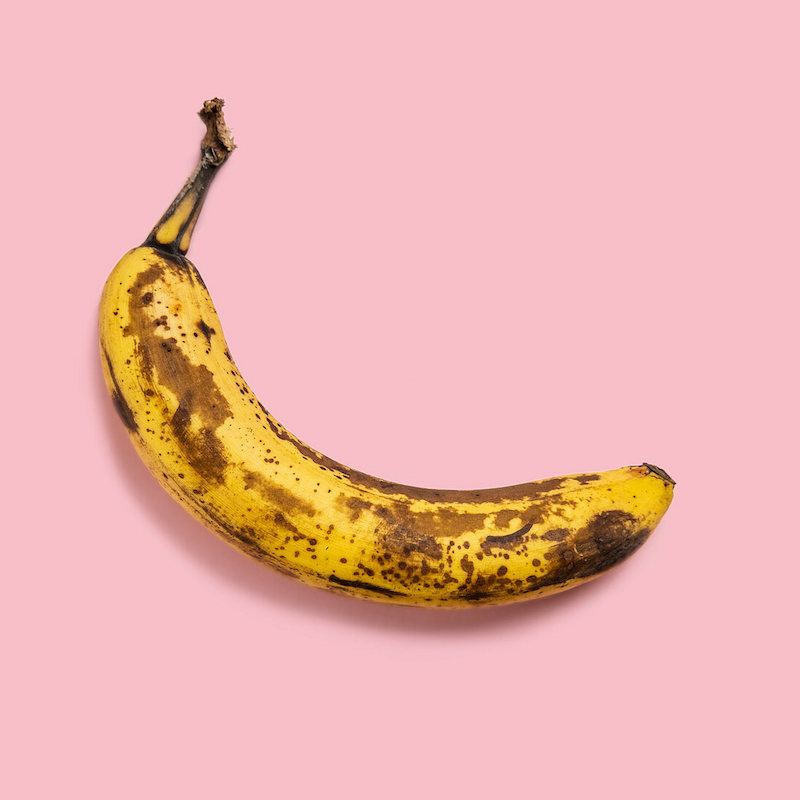 √úberreife banane auf rosa hintergrund