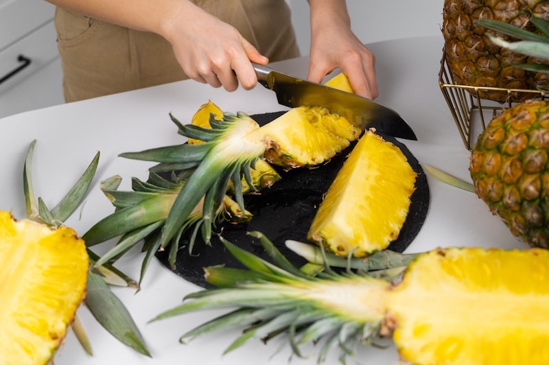 how to cut a pineappleperson cutting a pineapple