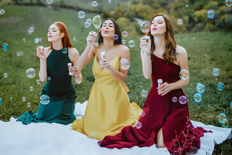 bridesmaid dresses three girls blowing bubbles