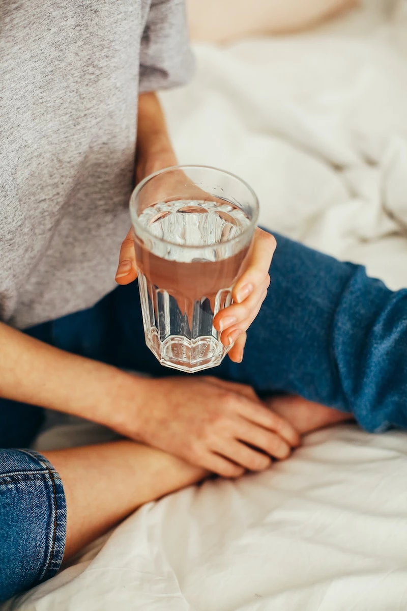 how to get rid of hangover headache woman with a glass of water