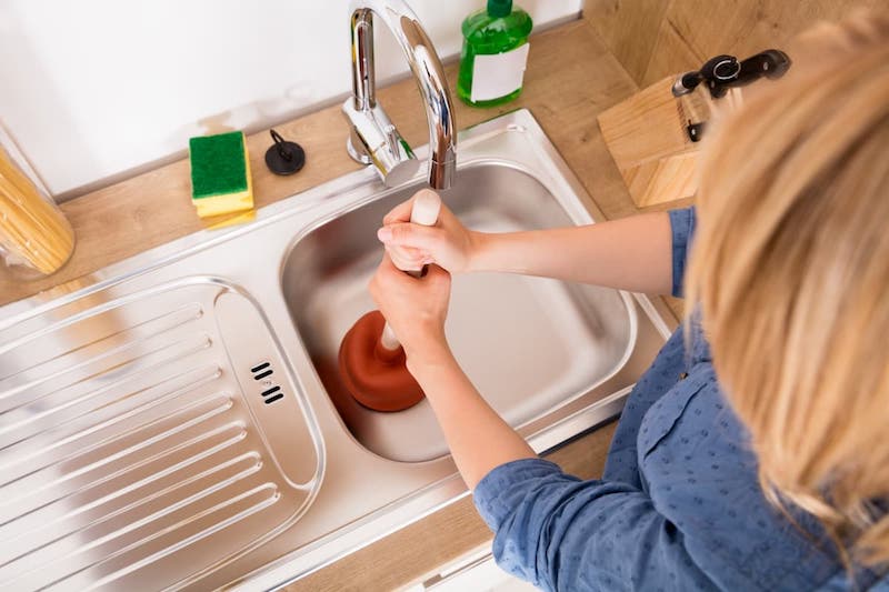 how to unclog a bathroom sink woman using plunger kitchen sink