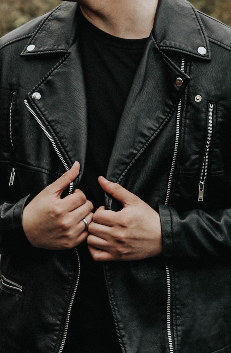 man holding his leather jacket
