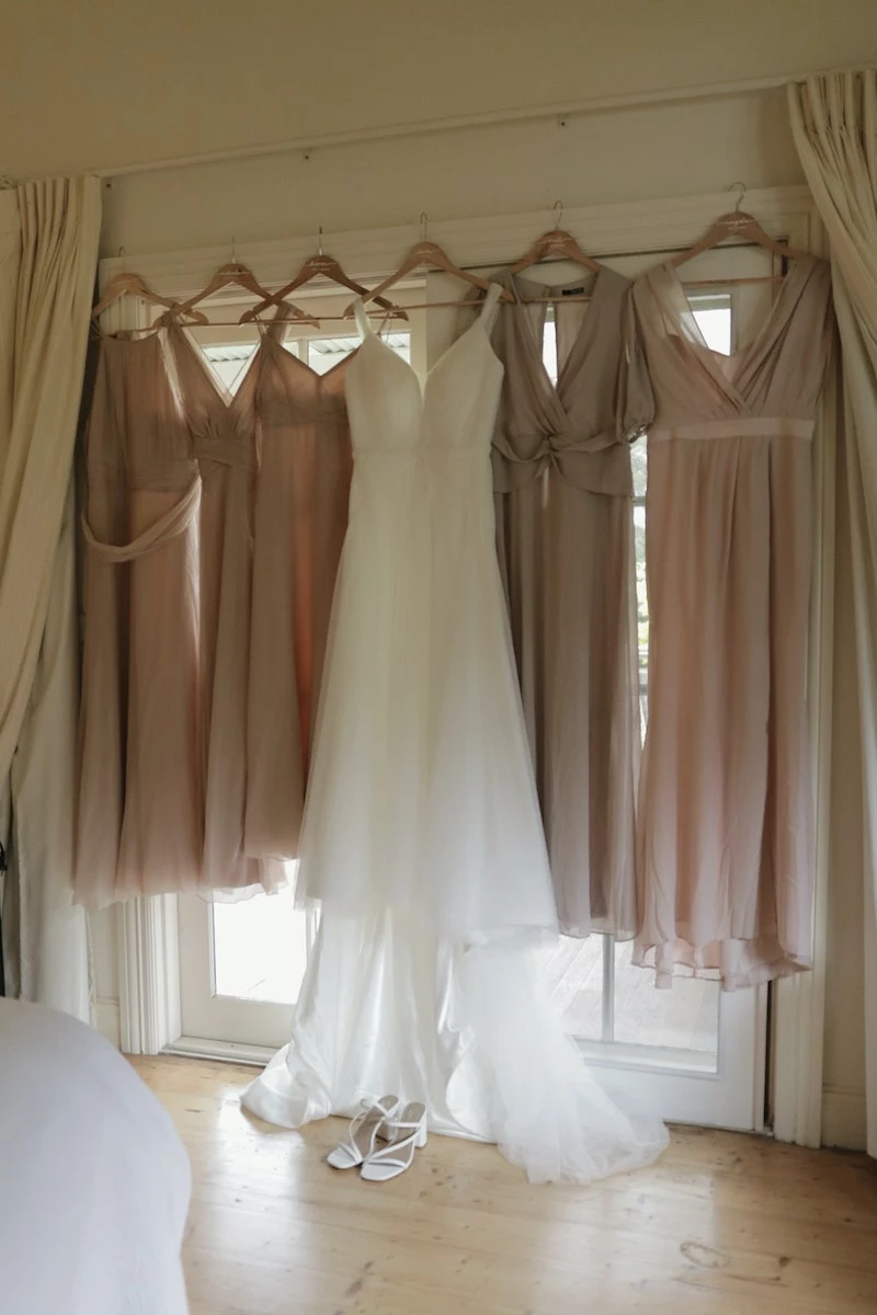 wedding dress with bridesmaids dresses on hangers