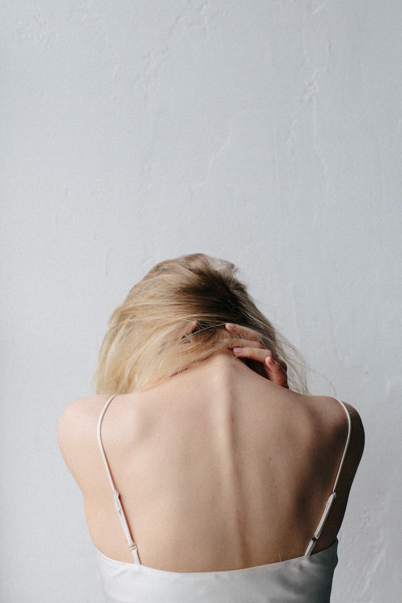 woman clinging her neck in pain