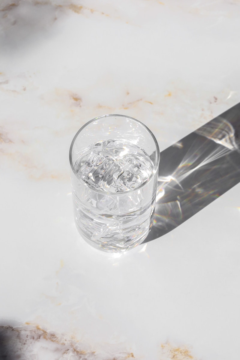 a glass of water on a marble counter