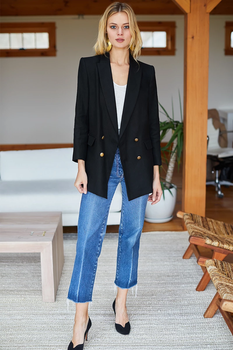 blond woman with black blazer white tee and jeans