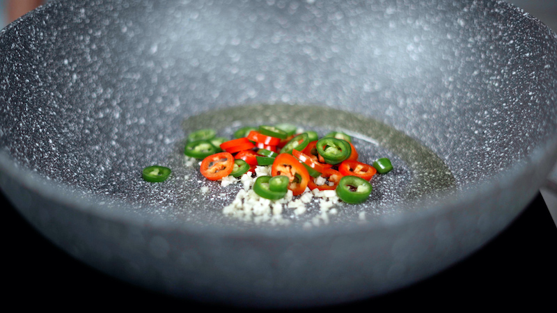 garlic and chili peppers in a wok close up for stir fry