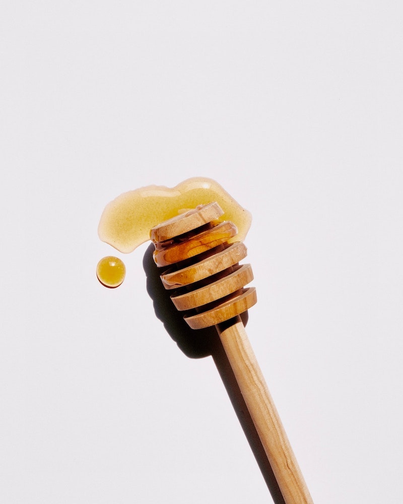 health benefits of honey honey spoon with some honey on a white background