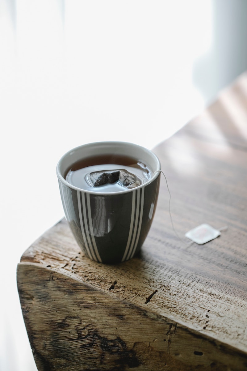 how to get rid of a stye teabag in tea in a cup on a wooden table