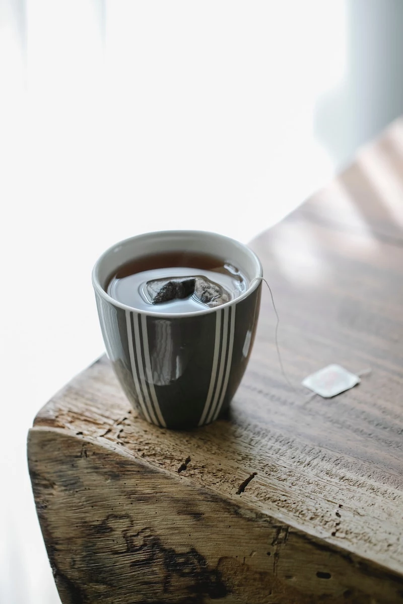how to get rid of a stye teabag in tea in a cup on a wooden table