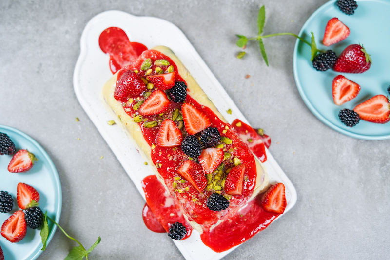 loaf of semifreddo with berries on top and puree
