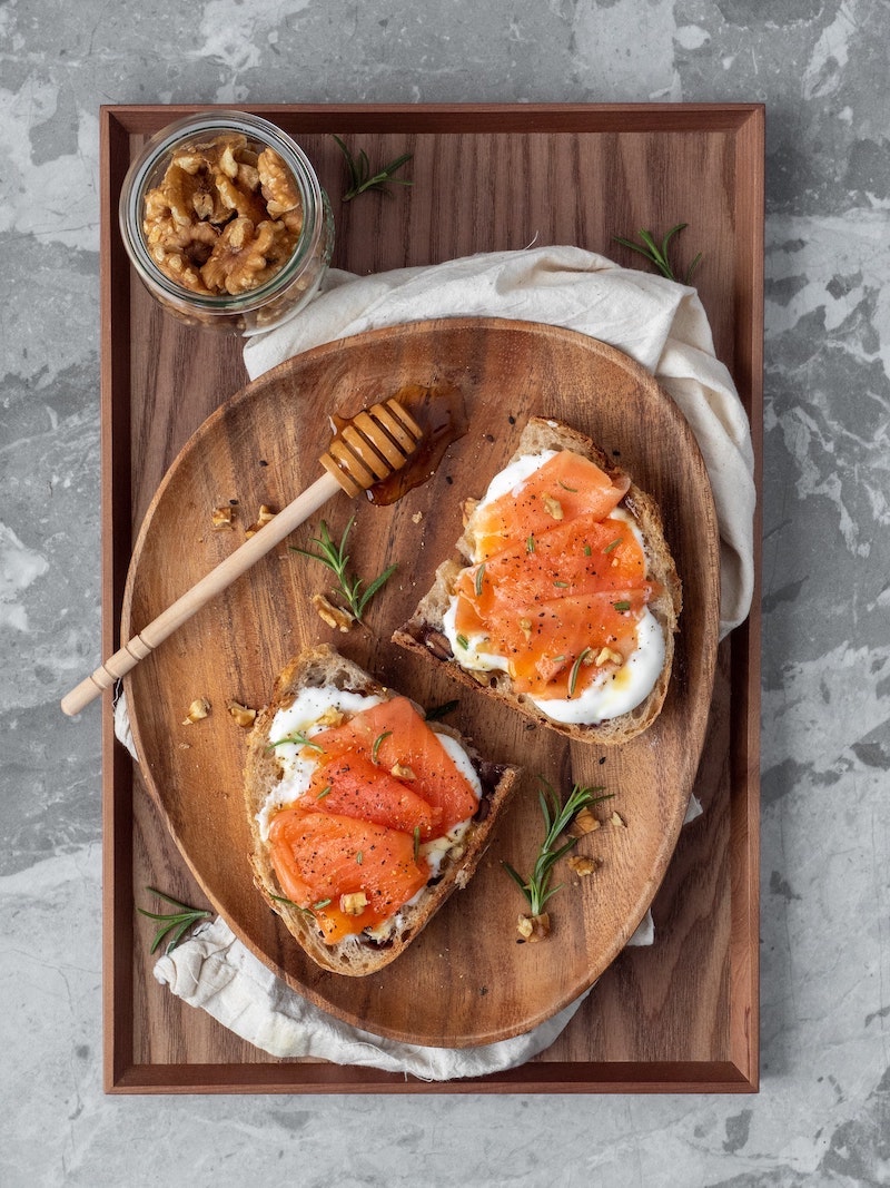 salmon on toast with cream cheese and wlanuts on the side