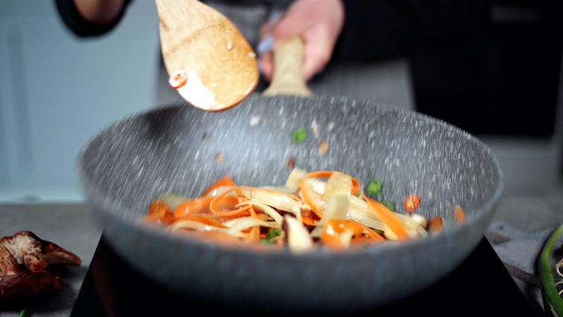 le verdure nel wok vengono mescolate e cotte