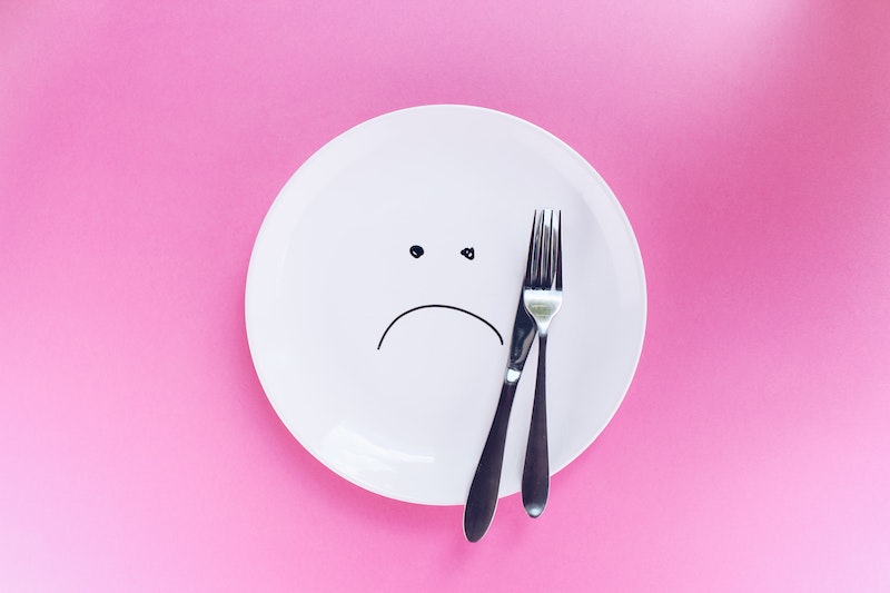 why am i gaining weight sad face on white plate with pink background