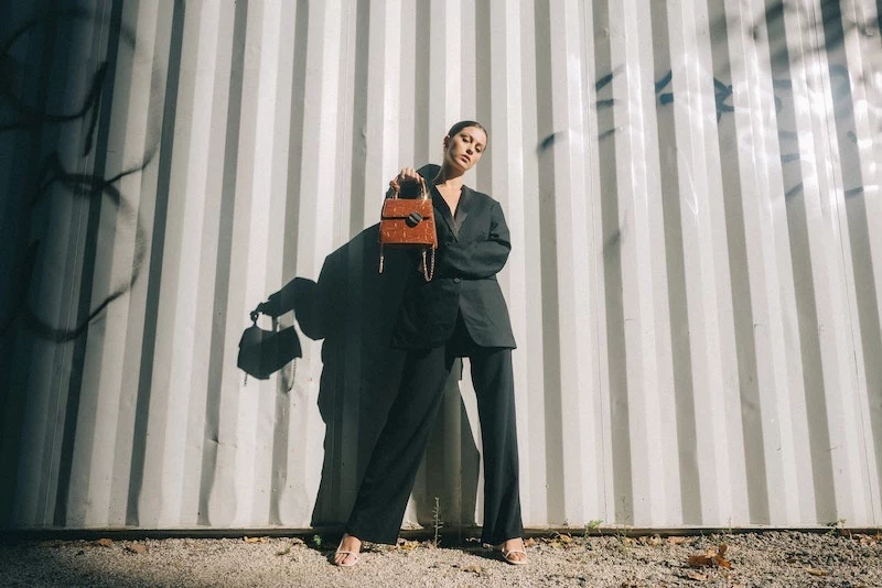 woman in black suit holding a bag